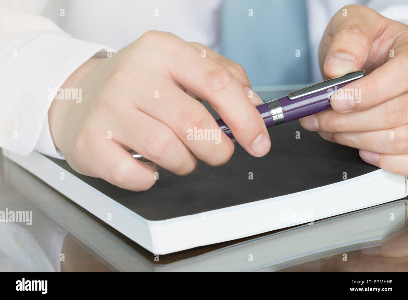 Geschäftsmann Hand mit Stift auf Notizbuch Stockfoto