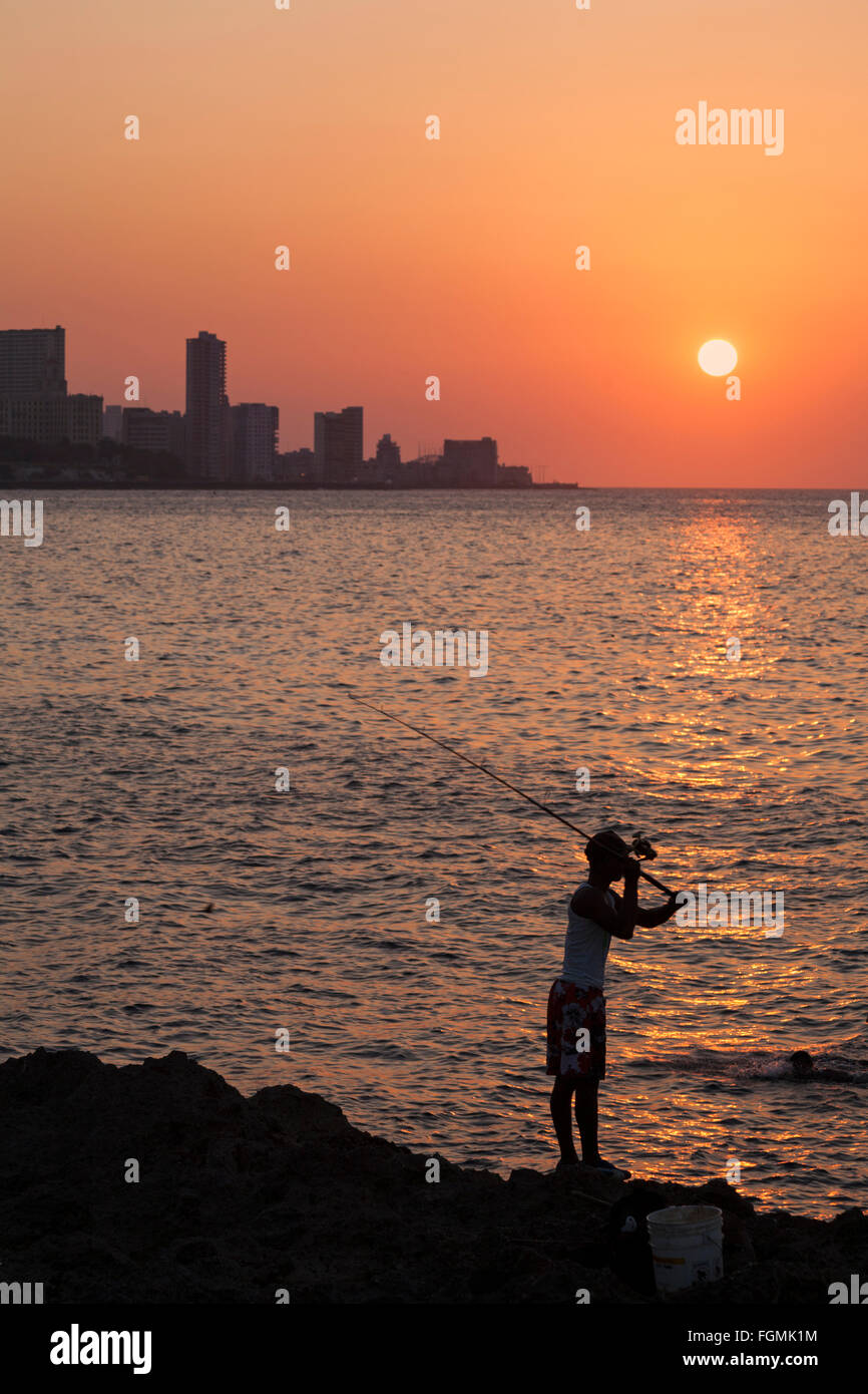 Das tägliche Leben in Kuba - Lokale Kubanischen männlichen Fischen, wie die Sonne über dem Meer in El Malecon, Havanna, Kuba, Karibik Karibik Mittelamerika - Sonnenuntergang Stockfoto