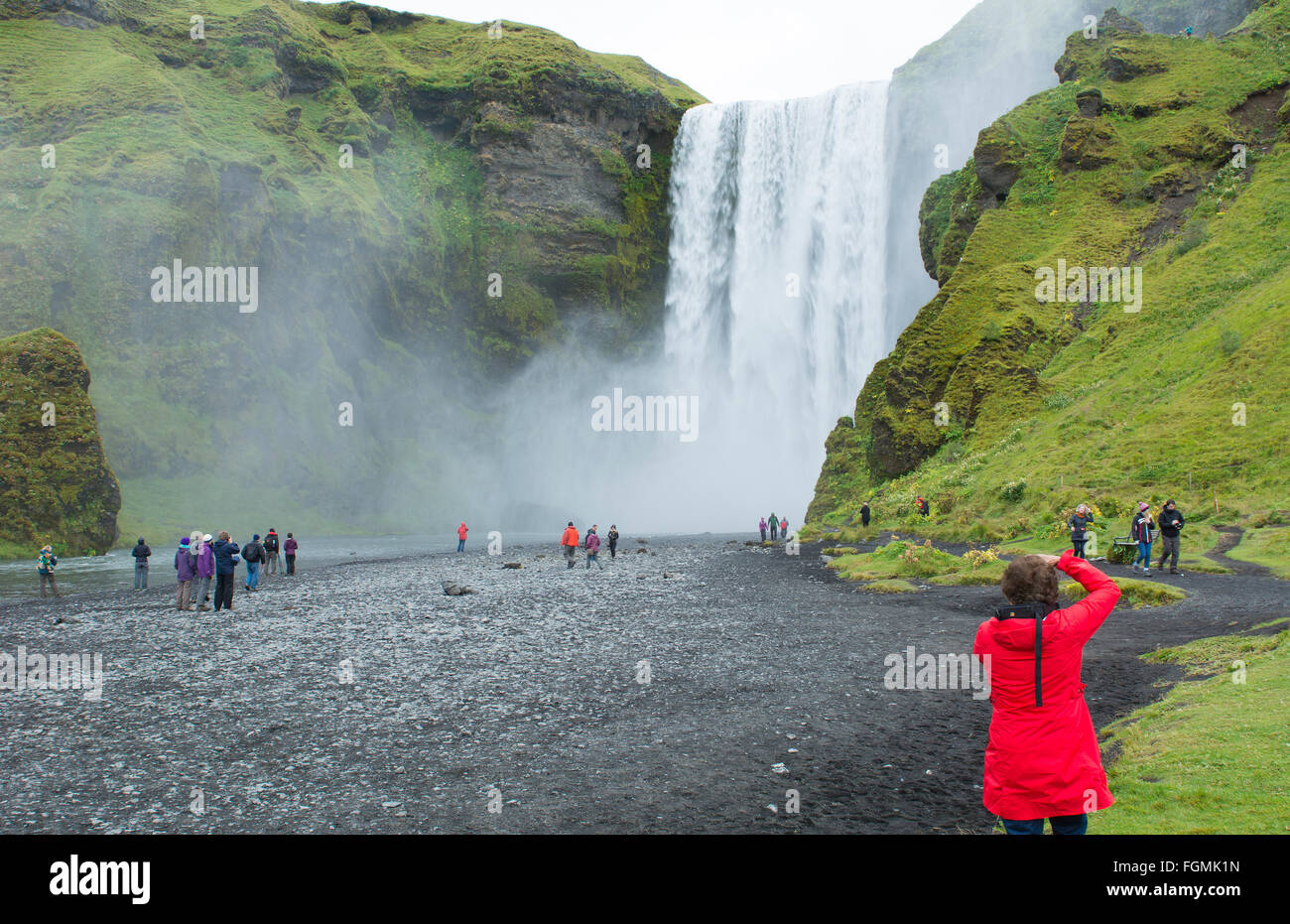 Berühmten Wasserfälle Skogafoss Wasserfall Islands im Süden Islands am Fluss Skoga mit Touristen fotografieren Modell veröffentlicht Stockfoto