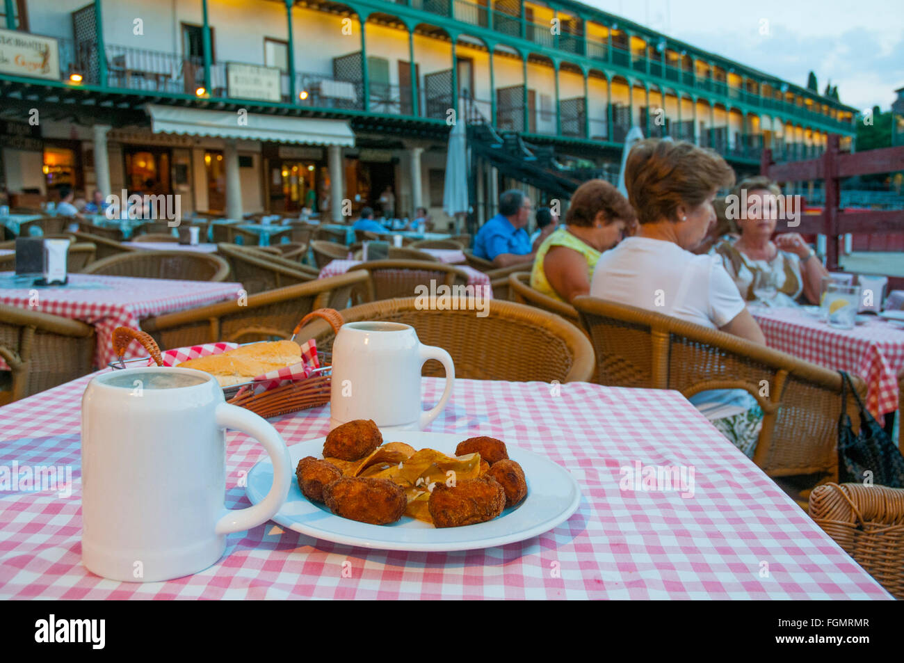 Spanische Tapa: Kroketten serviert und zwei Krüge Bier auf der Terrasse bei Einbruch der Dunkelheit. Hauptplatz, Chinchon, Madrid Provinz, Spanien. Stockfoto