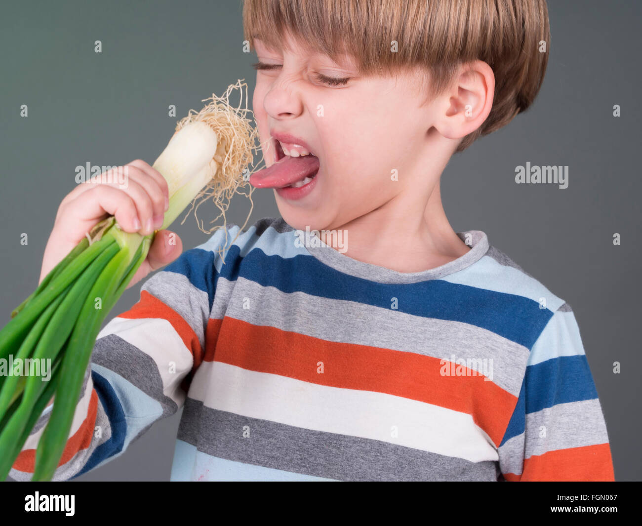 Lustige Kinder halten Lauch Gemüse, Weigerung zu essen Stockfoto