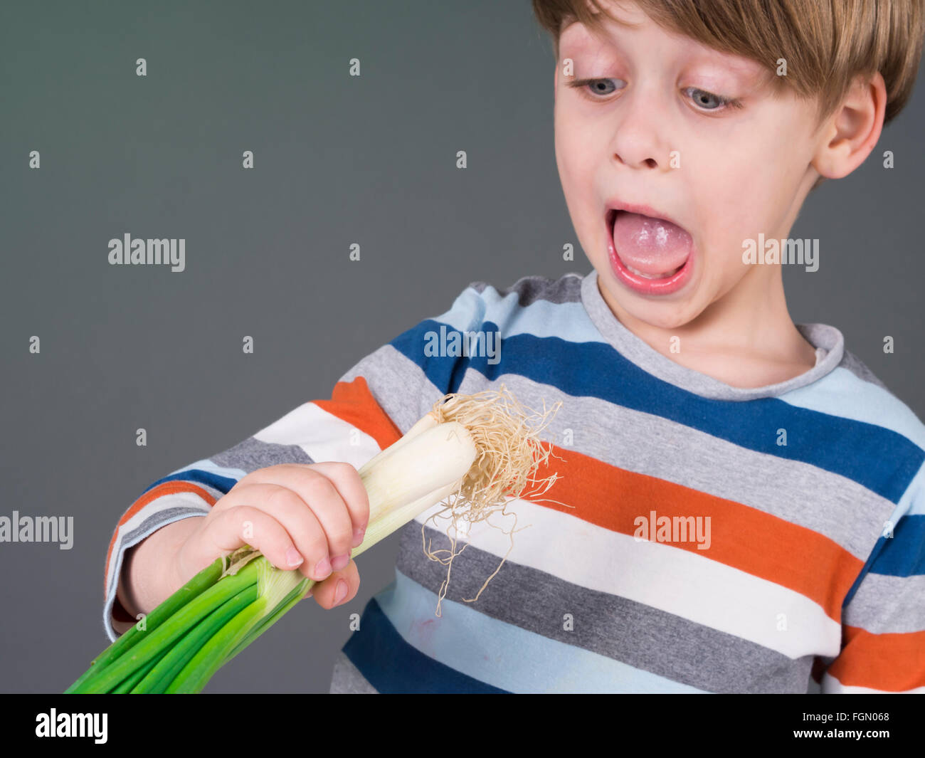 Lustige Kinder halten Lauch Gemüse, Weigerung zu essen Stockfoto