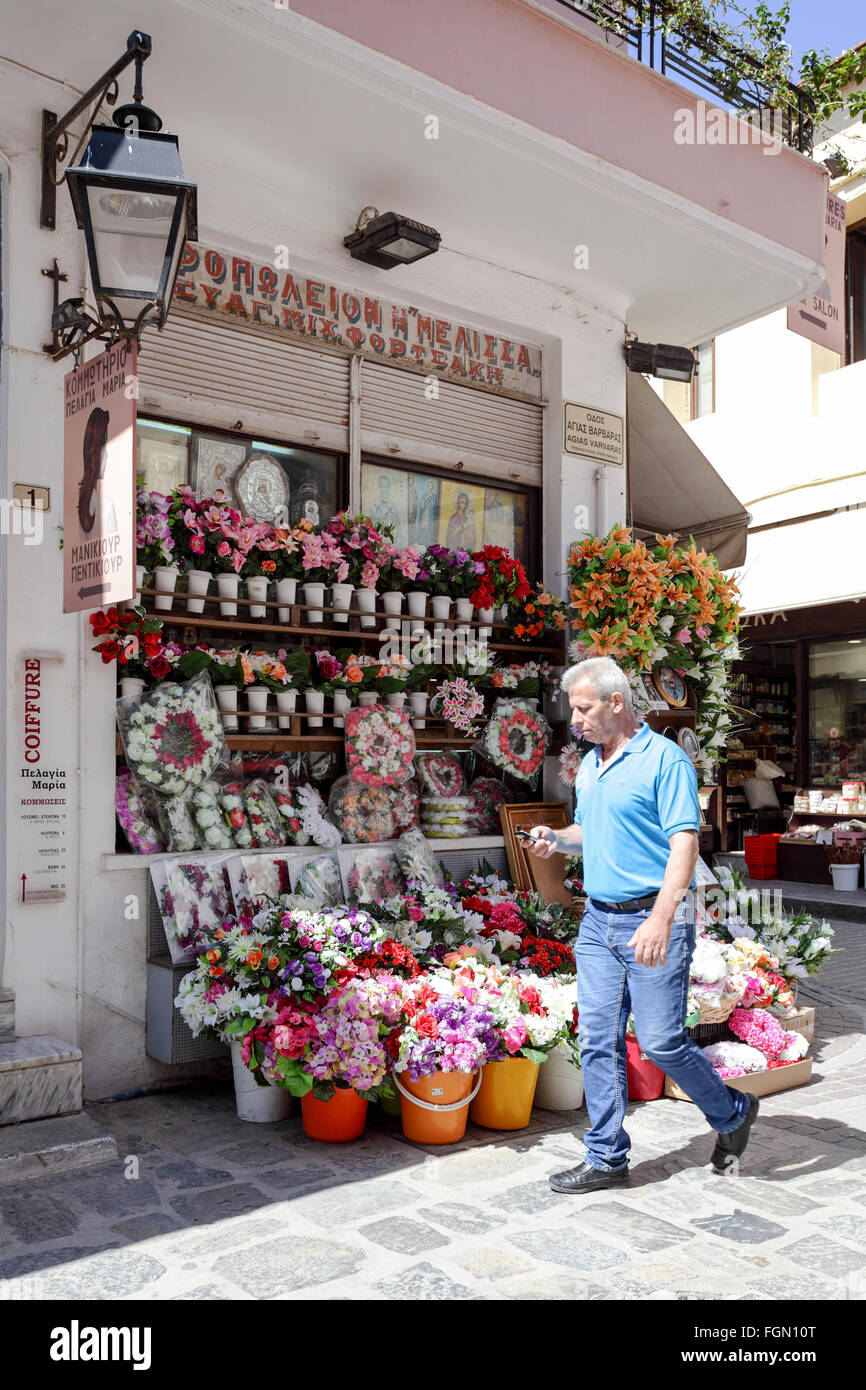 Wunderschön geschmückt kretischen Florist Verkaufsstelle mit Mann mittleren Alters zu Fuß direkt vor dem Geschäft. Stockfoto