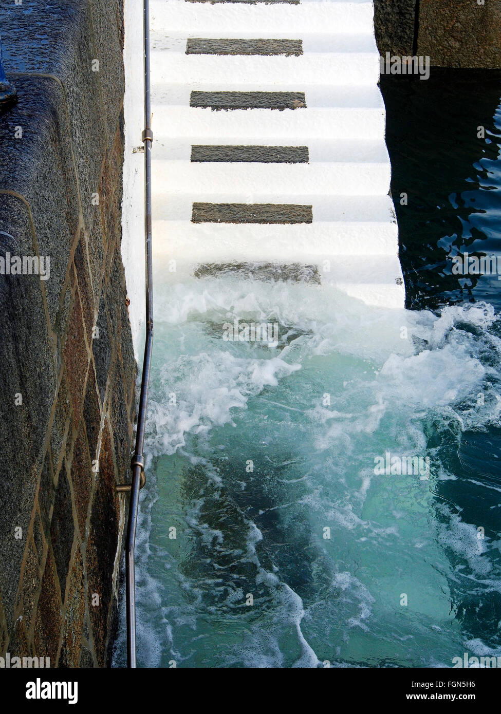 Klares Wasser wäscht die weiß lackierten Schritte in der Yacht-Hafen von St Peter Port, Guernsey Stockfoto