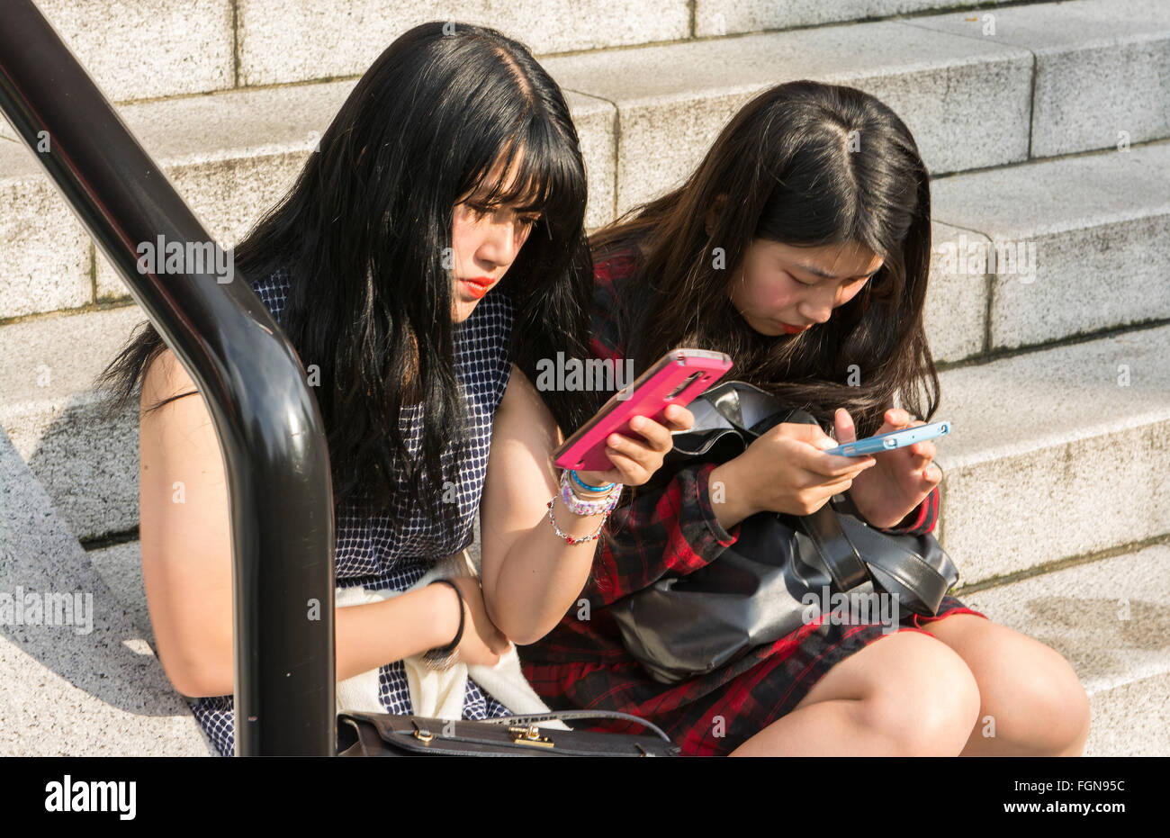 Tokyo Japan Teen Mädchen SMS auf Handys am Sensoji-Tempel auf Schritte Stockfoto