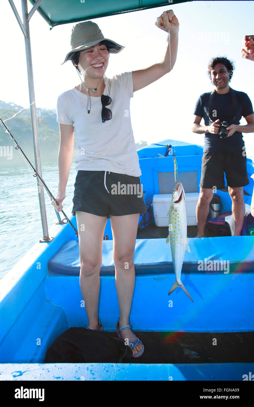 Ein asiatische weiblicher Touristen begeistert mit ihrem Fang des spanische Makrele Stockfoto