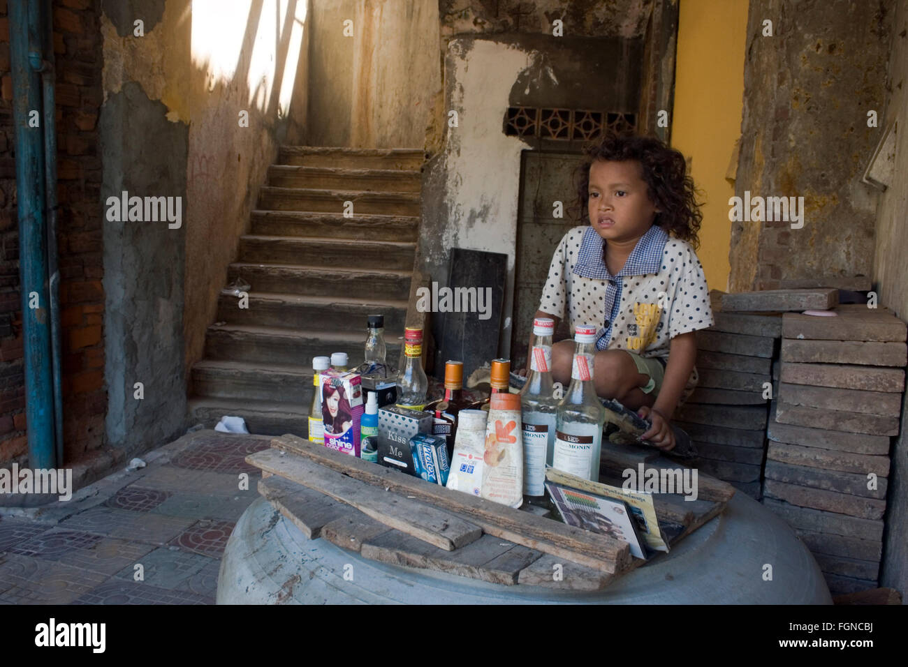 Ein junges Mädchen, die in Armut leben tendenziell eine machen glauben laden sie mit Müll in ihrem Haus in Kampong Cham, Kambodscha zusammengebaut. Stockfoto
