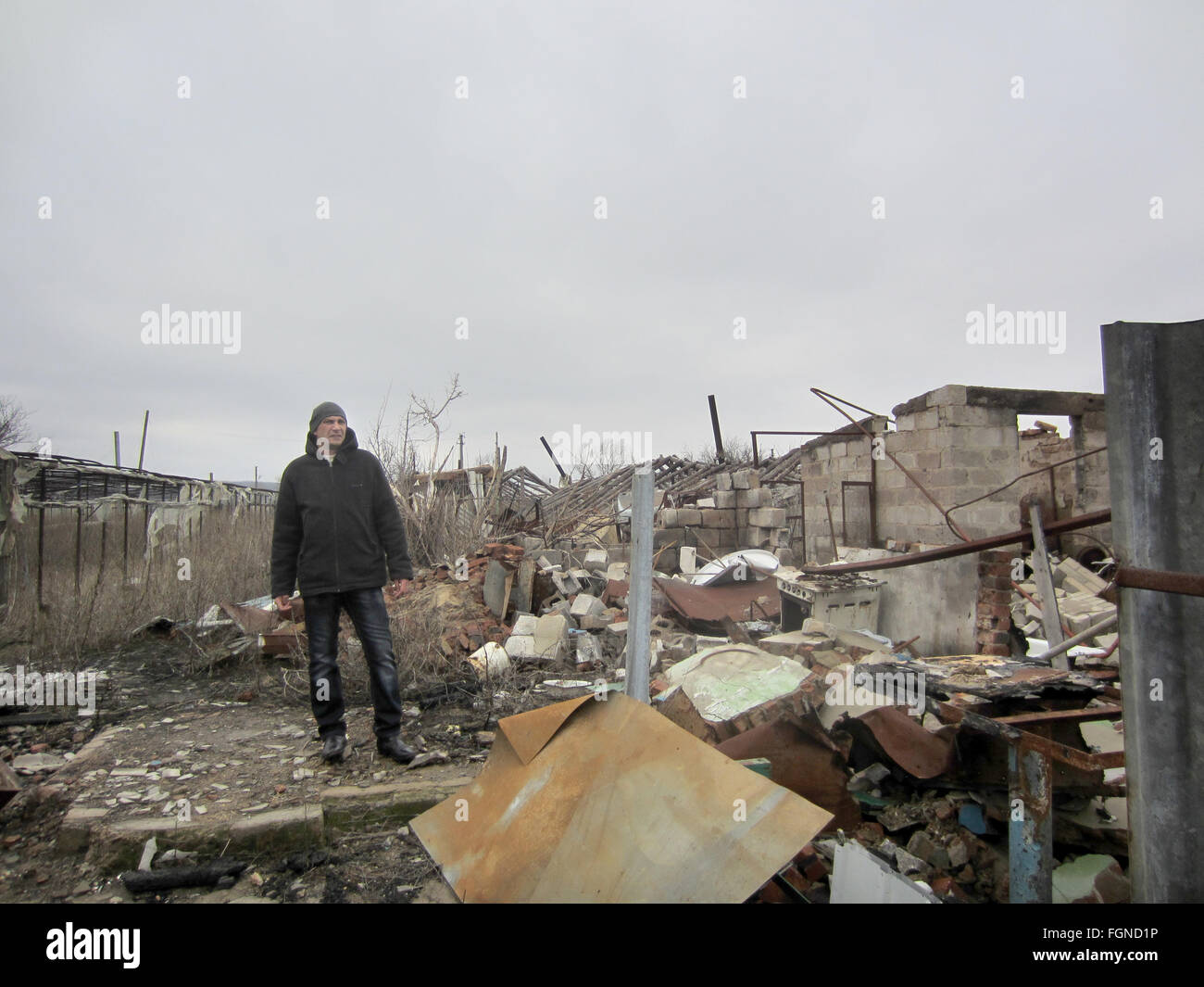 Victor steht auf den Ruinen seines Hauses in Stanytsia Luhanska, Ukraine, 3. Februar 2016. Vor dem Krieg waren Victor und seine Frau in der Lage, ihre Familie durch die Arbeit und das Ergebnis ihres Gewächshauses zu unterstützen. Jetzt, jedoch arbeitet er unter der Woche in der Regierung-gehaltenen Gegend sehen, seine Frau und Kinder nur am Wochenende, die auf die Rebellen kontrollierten Seite der Grenze leben. Wiederaufbau ihrer Heimat bleibt außerhalb ihrer Reichweite. Zwei Jahre nach der Revolution pro-westlichen die Ukraine ist ein Land, fragmentierte und Alltag in den Konfliktgebieten bleibt beschwerlich. Foto: Andreas Stein/dpa Stockfoto