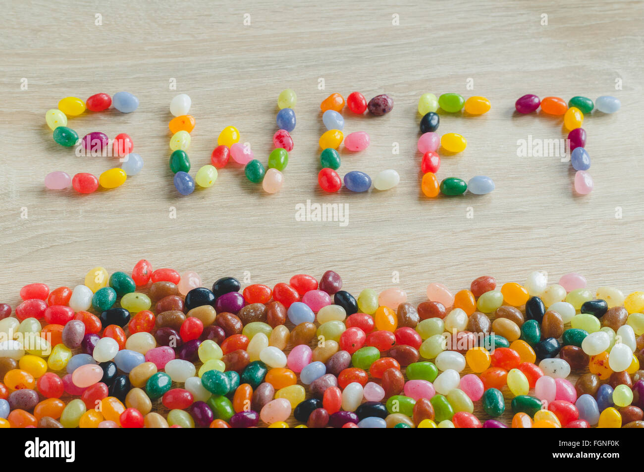 Wort-süß mit Rand von Gummibärchen auf hölzernen Hintergrund Stockfoto