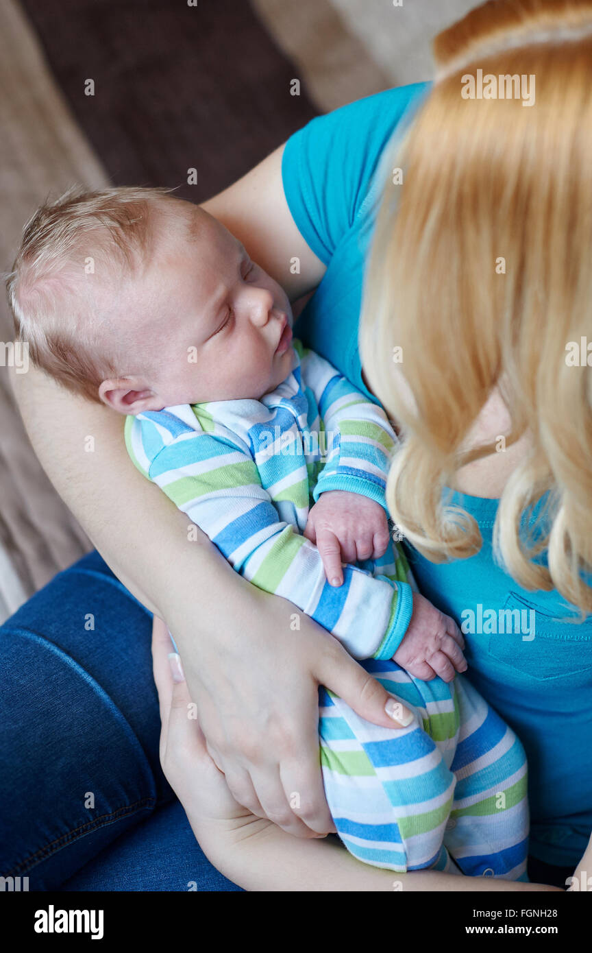 Liebevolle Mutter Hand mit niedlichen neugeborenen Kind schlafen Stockfoto