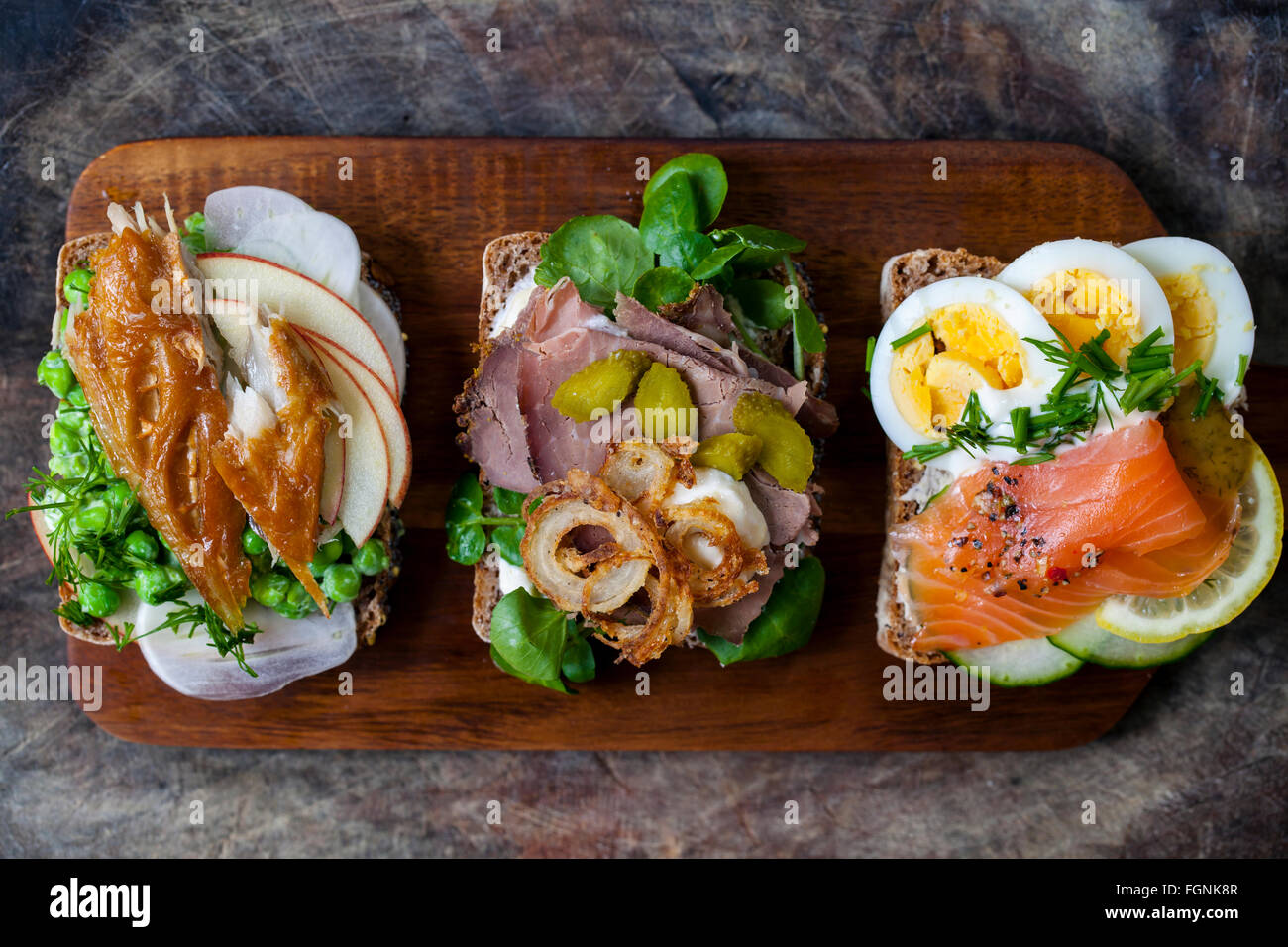 Skandinavische belegte Brötchen mit geräucherter Makrele, Lachs und Ei und Roastbeef und knusprigen Zwiebeln Stockfoto