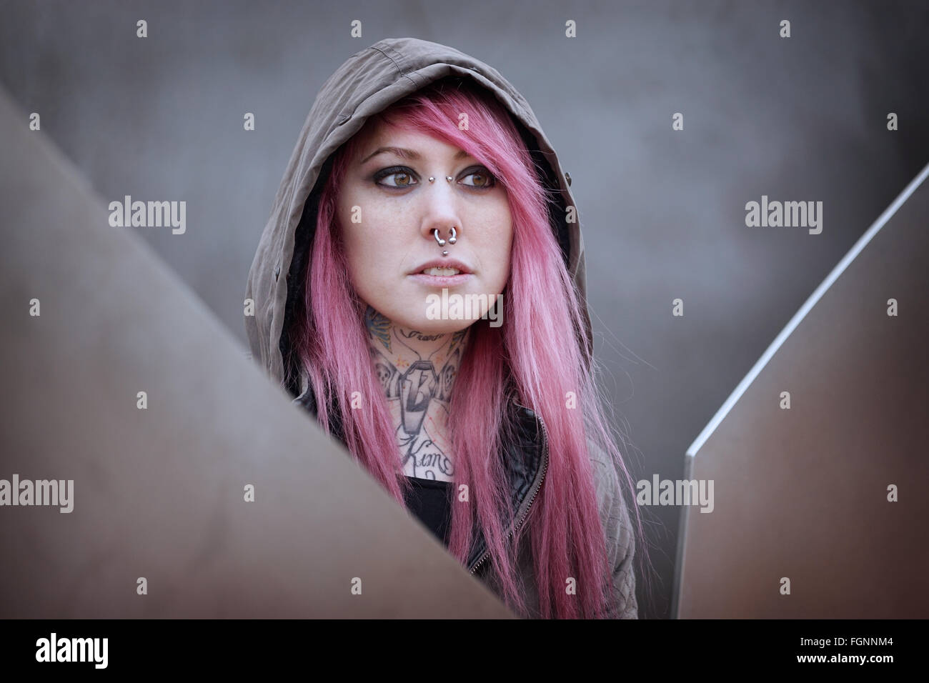 Frau mit rosa Haaren Piercings und tattoos Stockfoto
