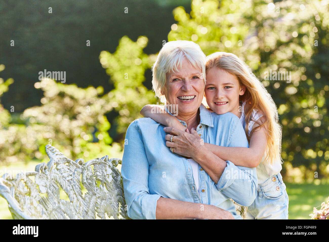 Porträt, Lächeln, Großmutter und Enkelin umarmt im Garten Stockfoto