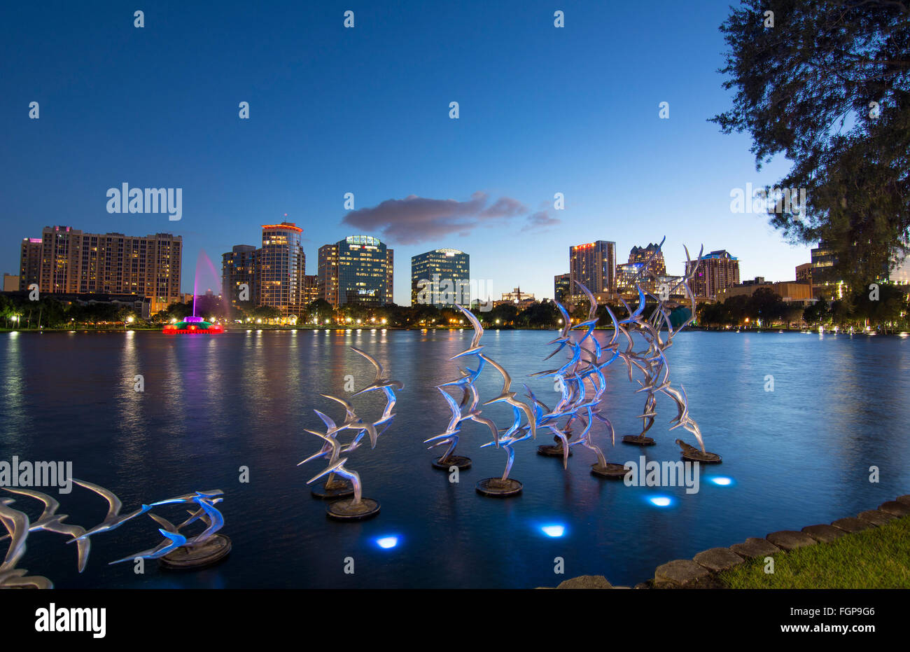 Skyline von Orlando Florida Lake Eola nehmen Flug begießen Blumberg bunte Dämmerung Nacht Lichter auf Vögel Statue Nacht Exposition mit s Stockfoto