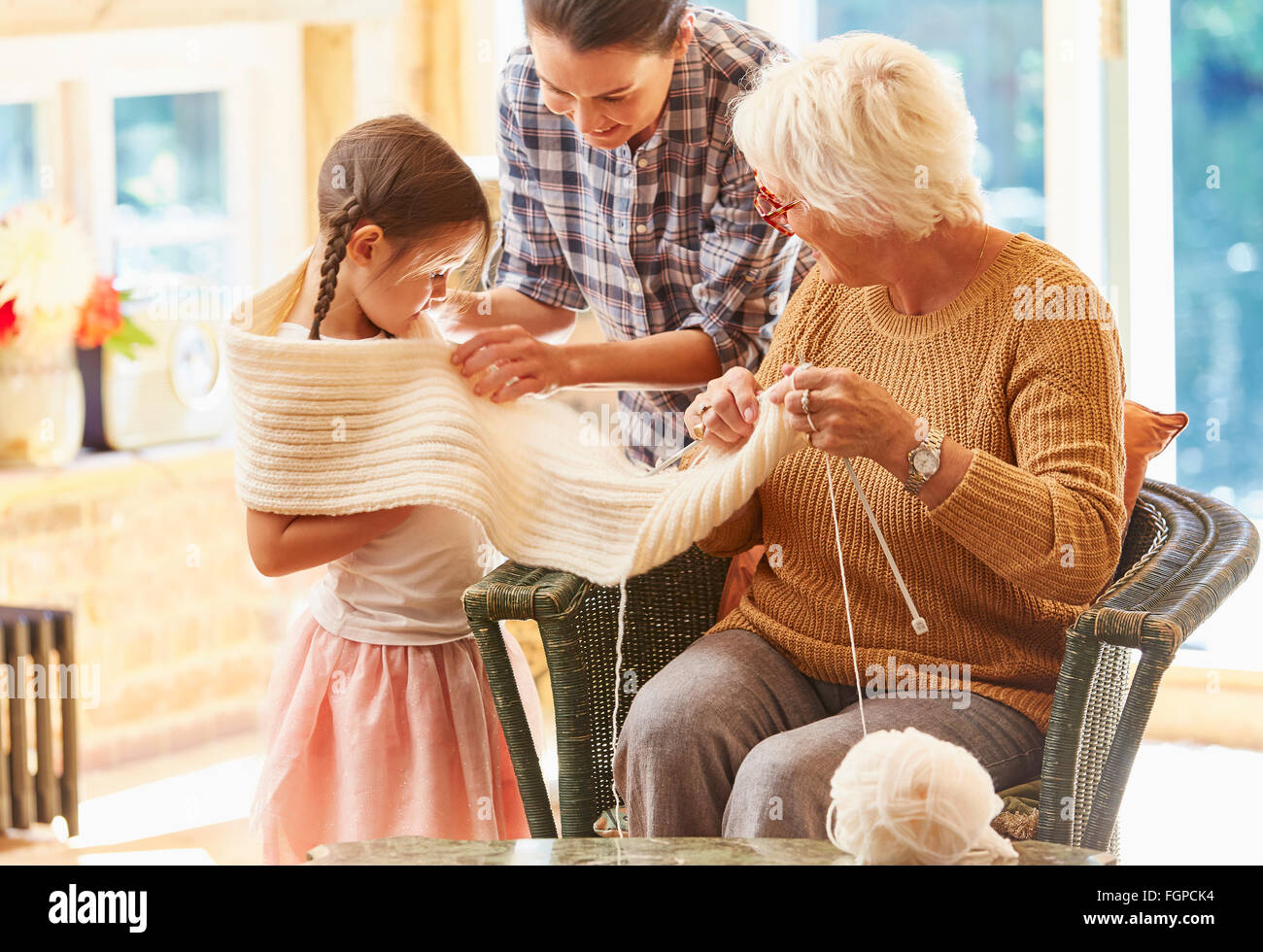 Großmutter stricken Schal um Enkelin Stockfoto