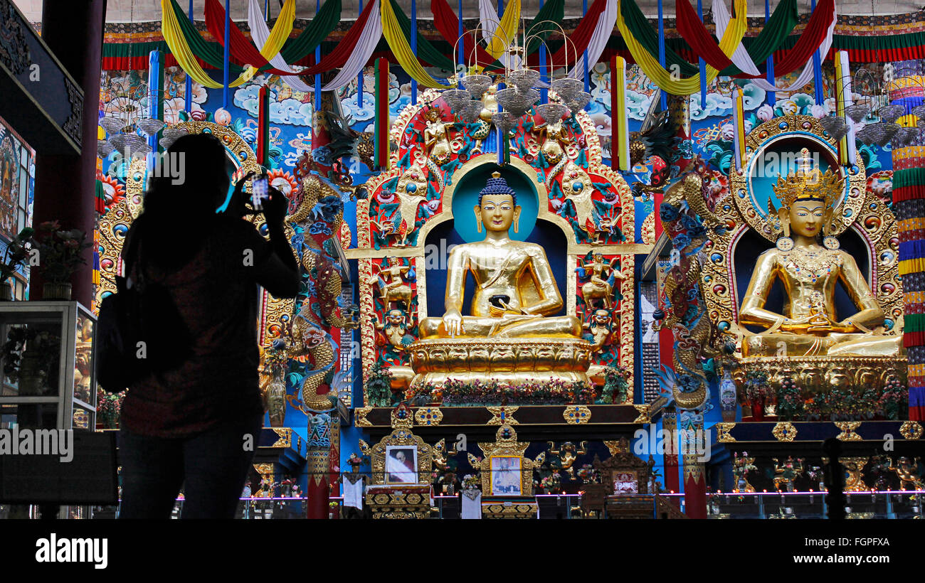 Eine Dame Klick Bild der goldenen Statuen mit ihrem Smartphone. Golden Buddhistentempel, Bylakuppe, Coorg, Karnataka, Indien, Stockfoto