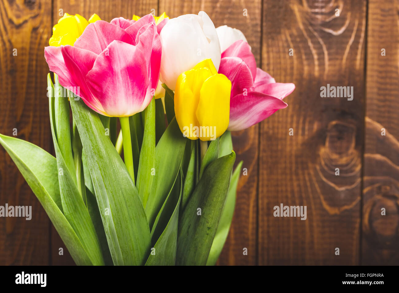Blumenstrauß aus Tulpen vor Druckfeder Szene auf dem hölzernen Hintergrund. Ein Blumenstrauß für den 8. März, oder zum Valentinstag Stockfoto