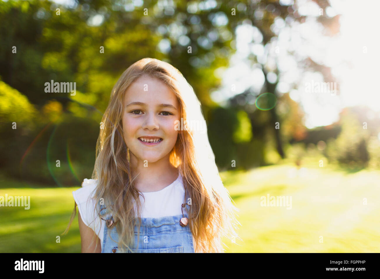 Porträt, lächelndes Mädchen im sonnigen Garten Stockfoto