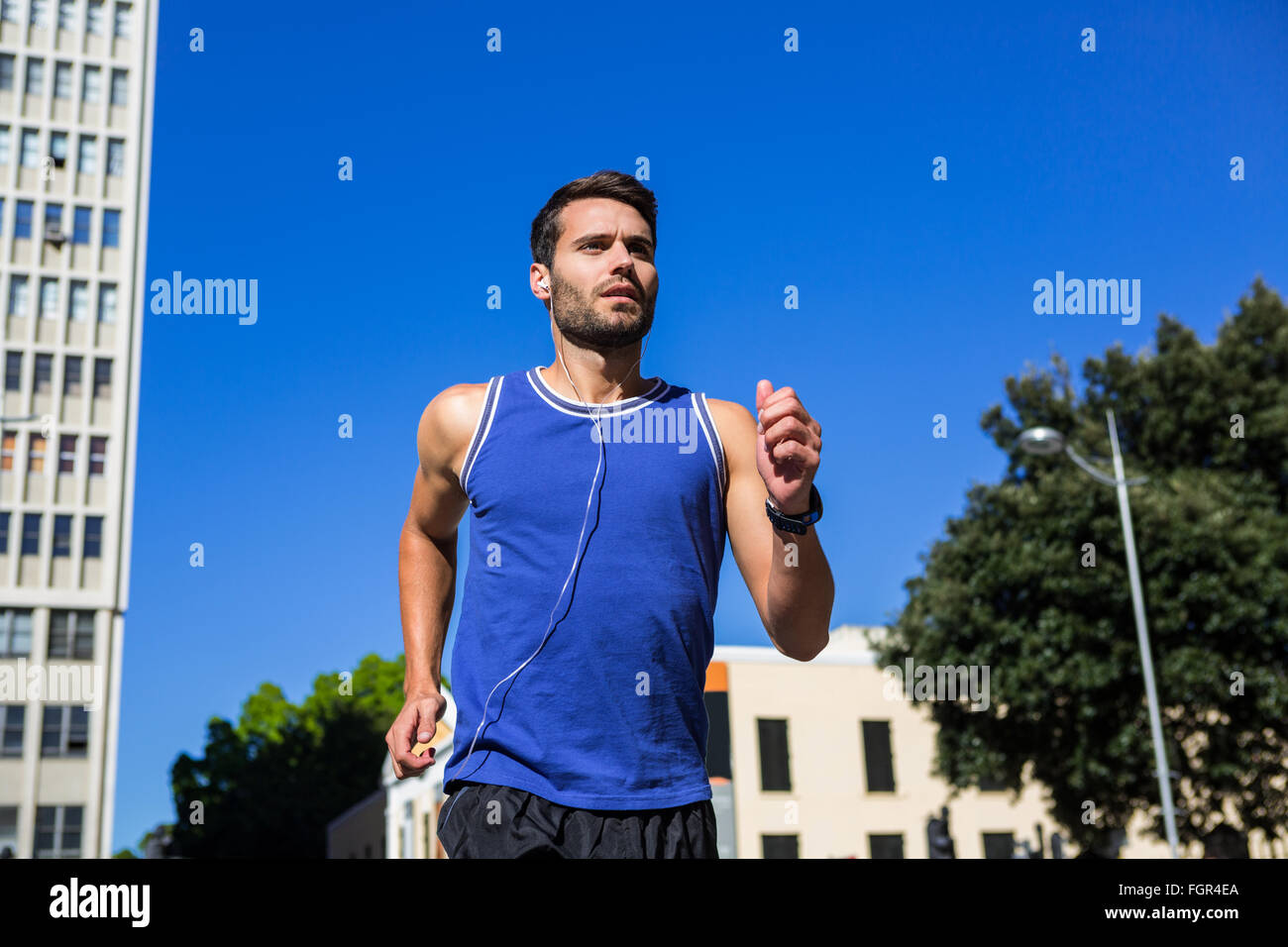 Schöne Sportler Joggen gegen blauen Himmel Stockfoto