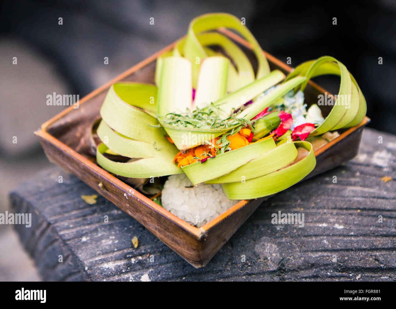 Einen Korb aus Kokos hergestellt Blätter und voller Blumen, Reis und anderen Opfergaben an die Götter zu besänftigen. Stockfoto