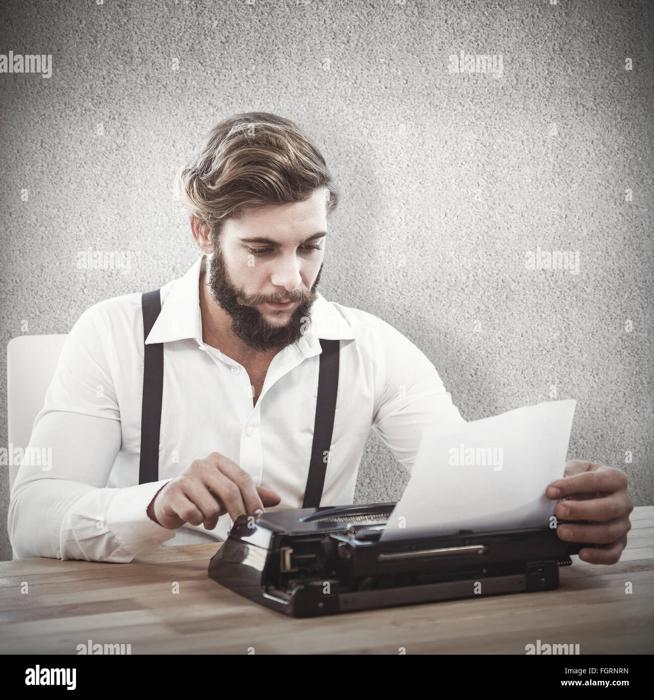 Zusammengesetztes Bild Hipster mit Schreibmaschine am Schreibtisch im Büro Stockfoto