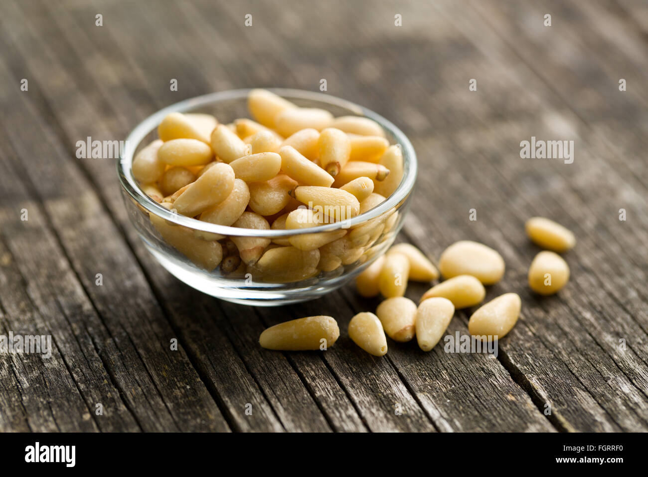 Pinienkerne in Schüssel auf alten Holztisch Stockfoto