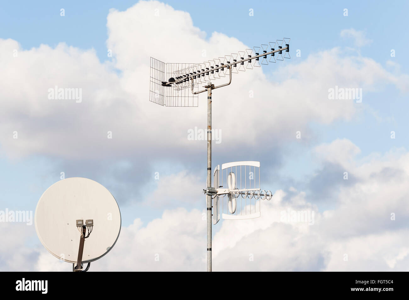 TV-Antenne und Satellitenschüssel vor blauem Himmel Stockfoto