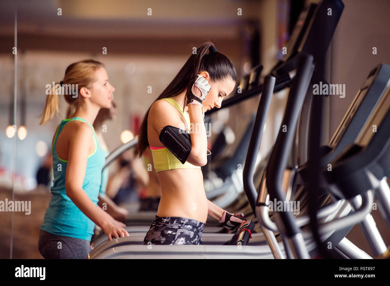 Zwei passen Frauen laufen auf Laufbändern im modernen Fitnessraum Stockfoto