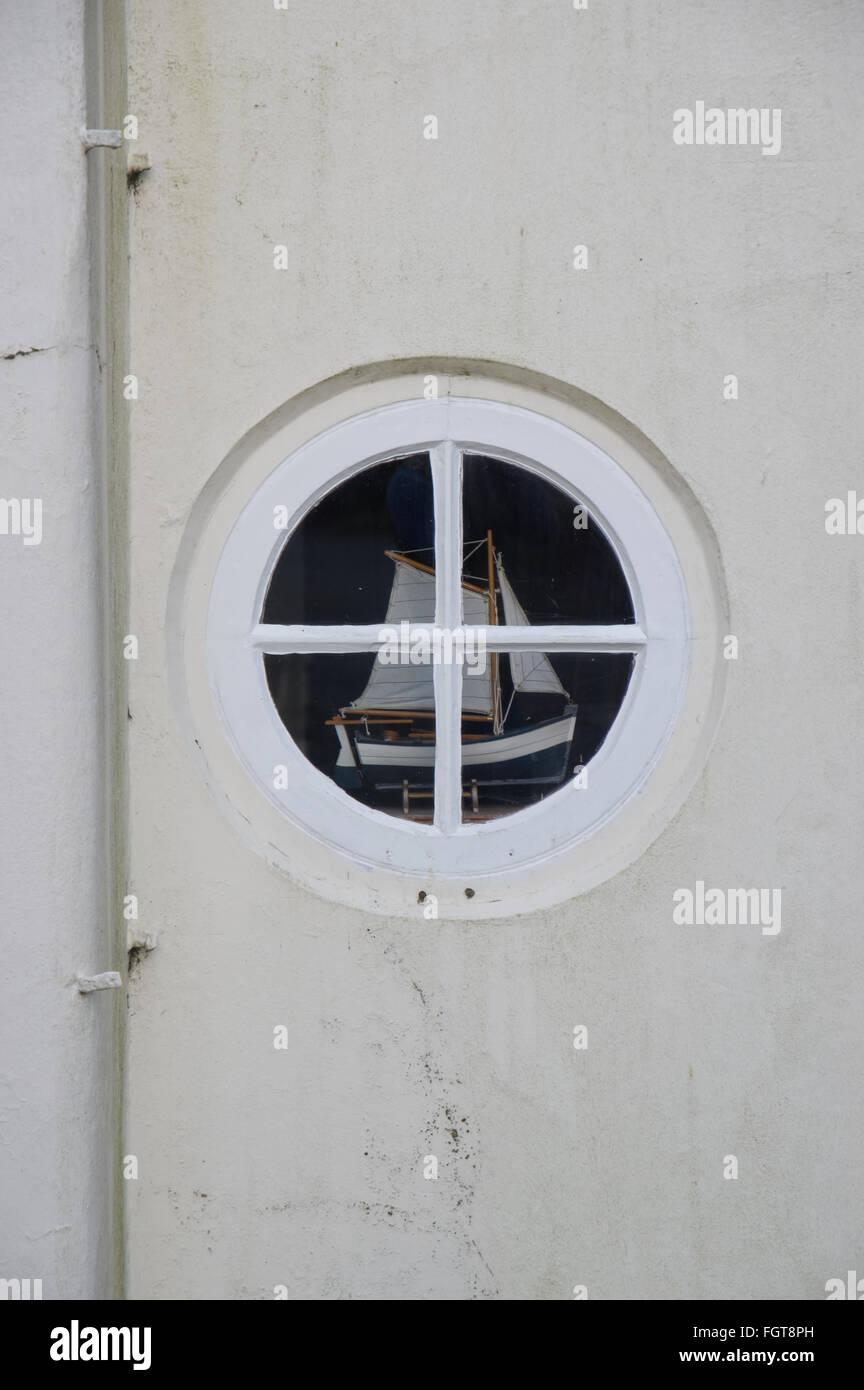 Ein Modellschiff, gesehen durch ein kleines rundes Fenster. Stockfoto