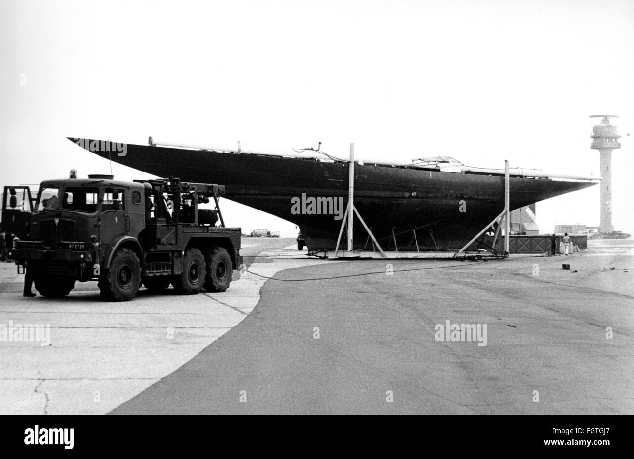 AJAXNETPHOTO. 1979. CALSHOT, ENGLAND. DIE 1930S J-KLASSE ENDEAVOUR WURDE VON DEN KÖNIGLICHEN INGENIEUREN DER ARMEE MIT EINER SATTELZUGMASCHINE AN DER CALSHOT SPIT AN LAND GEZOGEN. DER NEUE BESITZER JOHN AMOS PLANT DEN WIEDERAUFBAU DER 128-FT-YACHT, DIE EINST IM BESITZ DES AMERICA'S CUP CHALLENGER SIR.T.O.M. SOPWITH WAR. FOTO: JONATHAN EASTLAND/AJAX REF:ENDEAVOUR BWP 78 Stockfoto