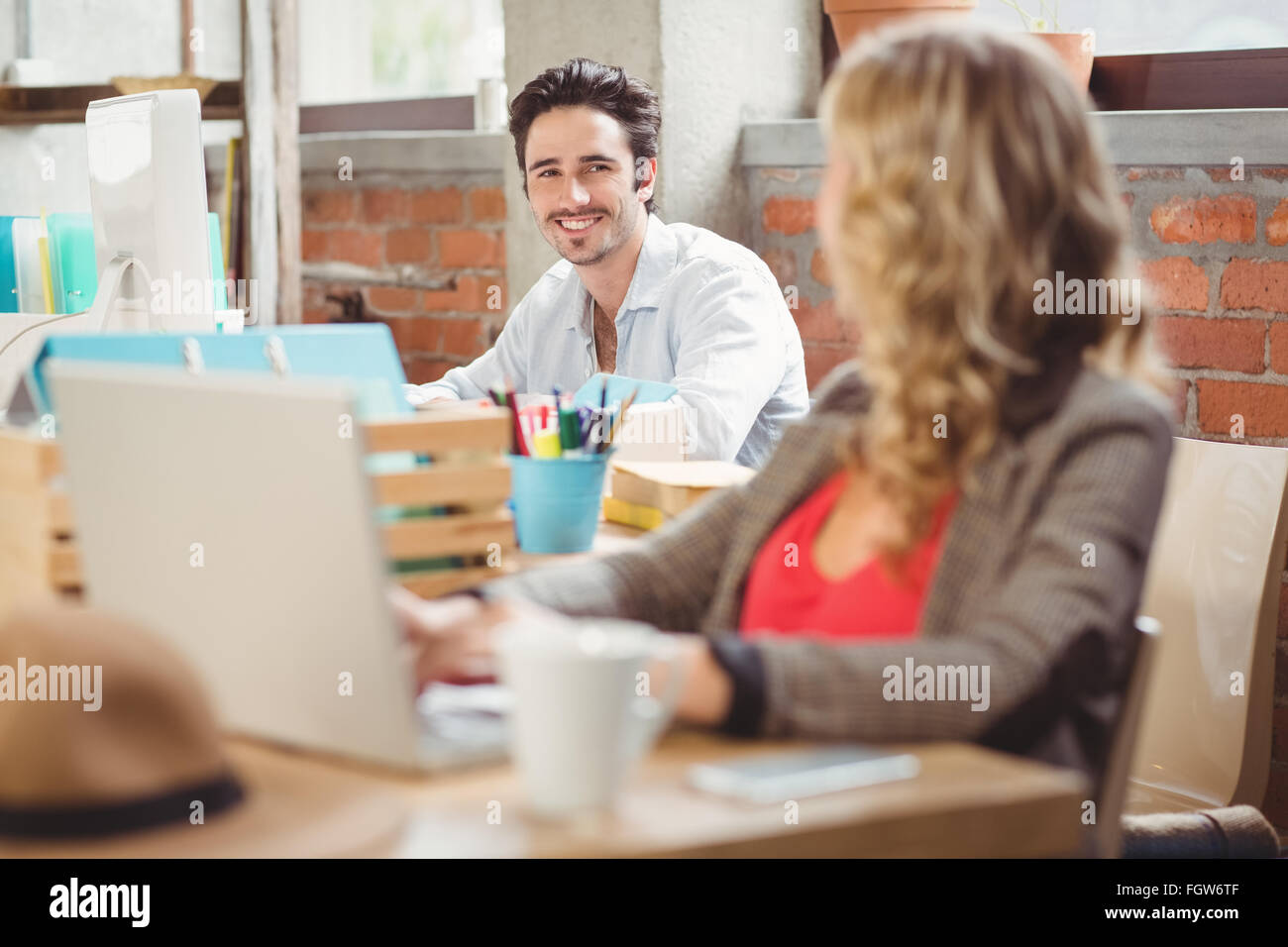 Lächelnd jungen Geschäftsmann arbeiten am Computer im Büro Stockfoto