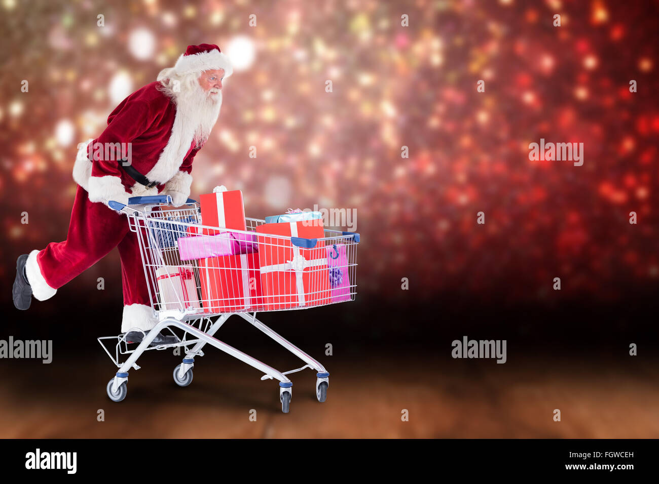 Zusammengesetztes Bild von Santa schiebt einen Einkaufswagen Stockfoto