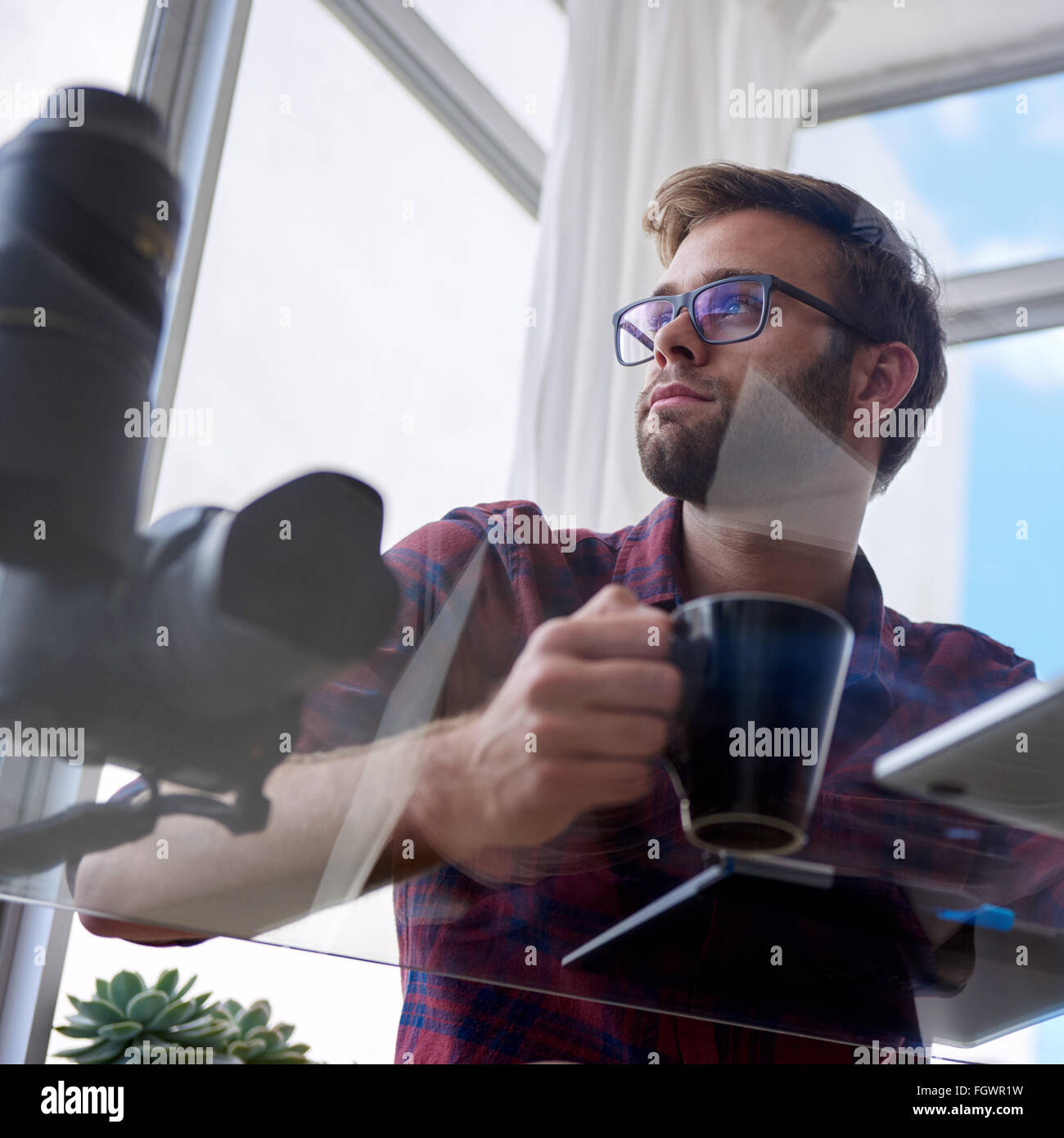 Junge Arbeiter geschossen unter einem Glastisch Stockfoto