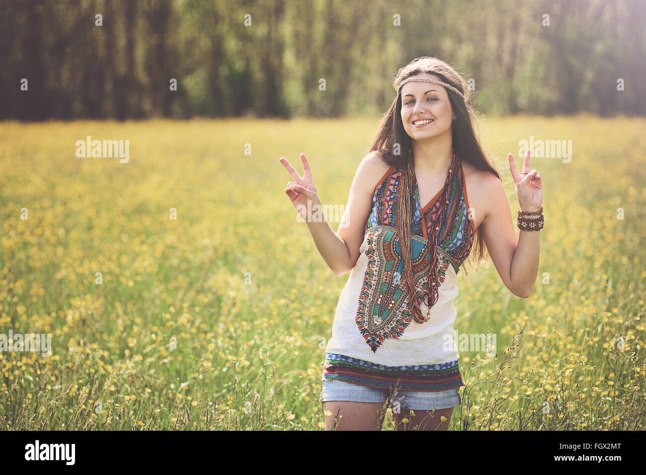 Peace-Zeichen aus lächelnden Hippie auf einer Wiese. Freiheit und Harmonie Stockfoto