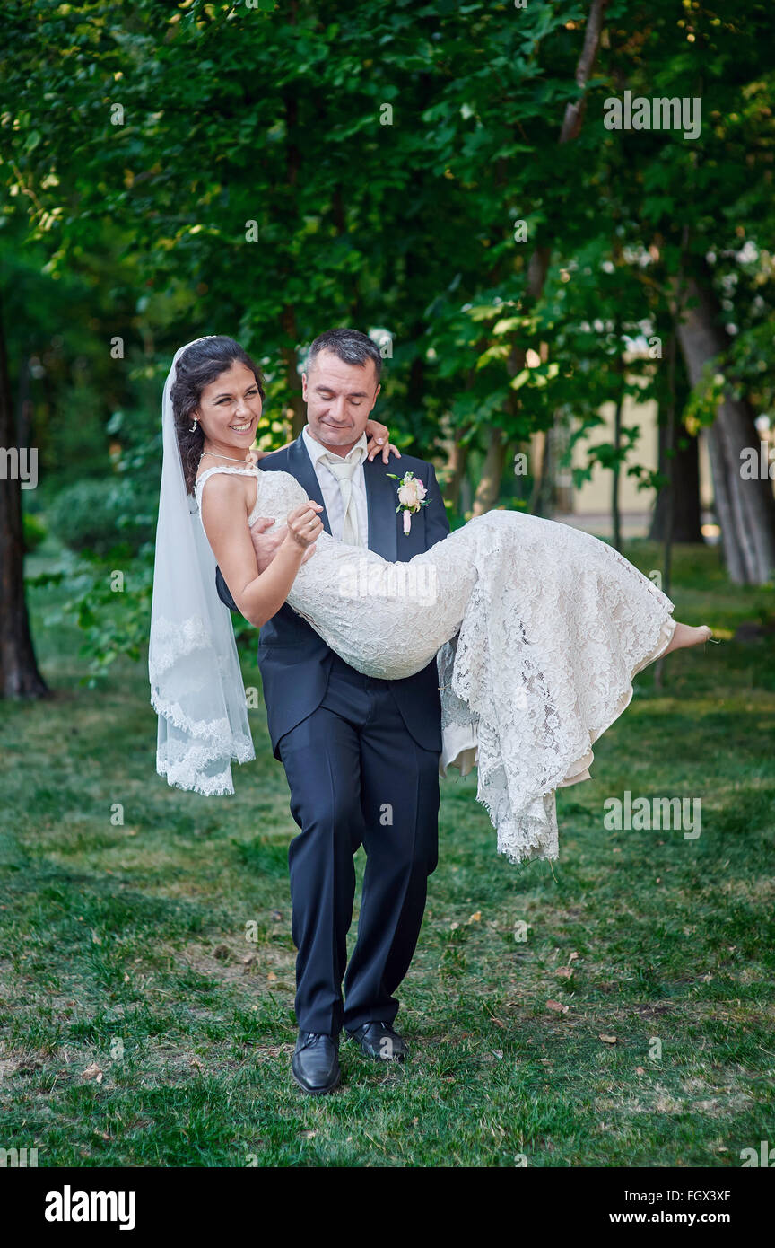 Bräutigam hält seine Braut in seine Arme und ein Lächeln des Glücks Stockfoto