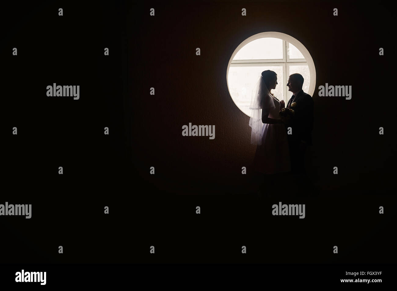 Silhouette der Braut und Bräutigam auf dem Hintergrund des Fensters Stockfoto