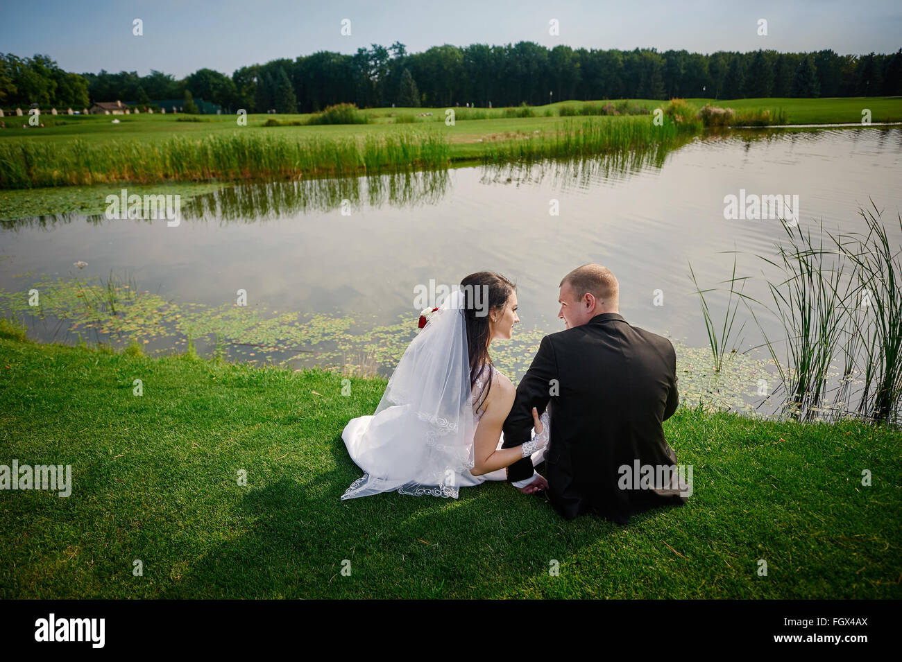 Bräutigam und die Braut-Wanderung in der Nähe von dem See am Tag ihrer Hochzeit Stockfoto