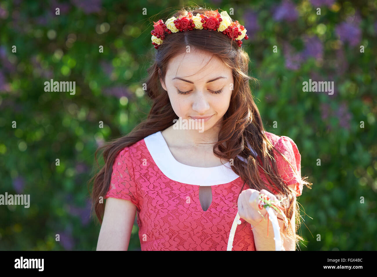 Junge Frau mit Kranz und mit lila Blüten im Frühling Stockfoto