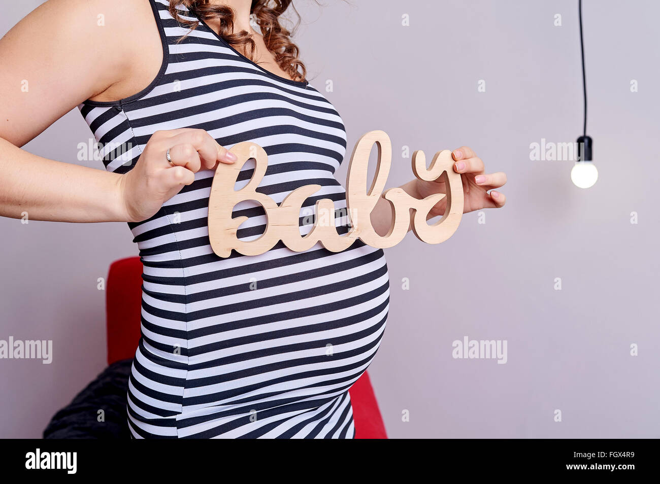 Schwangeren Bauch mit Symbol Text Baby in ihren Händen Stockfoto