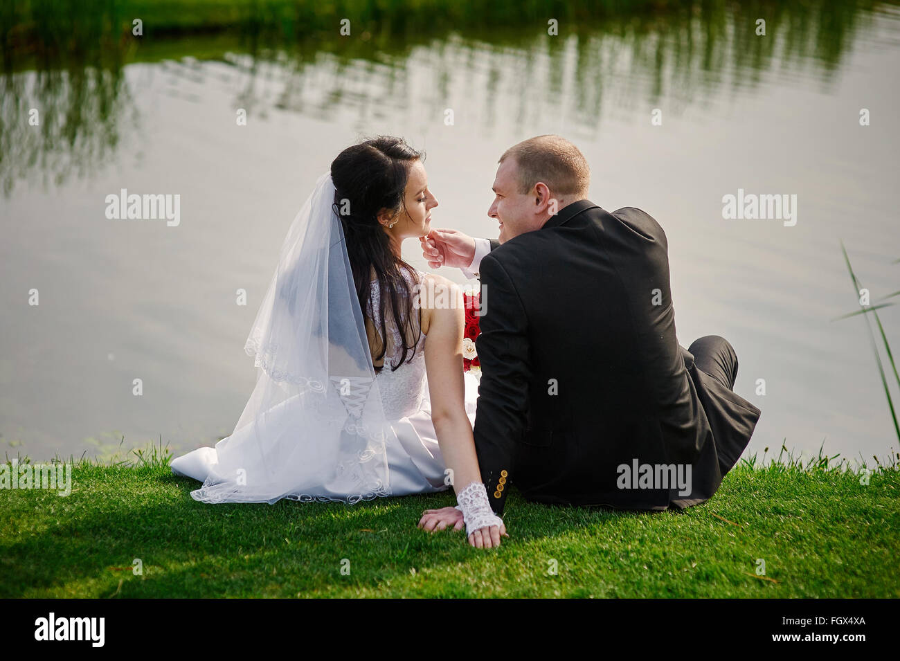 Schönen Ehepaar sitzt am Ufer im Sommer Stockfoto