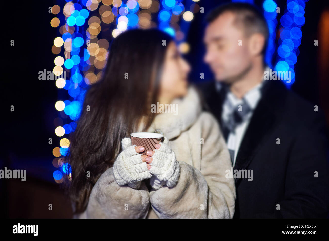 Frau mit einem Kaffee in der Winter-Handschuhe Stockfoto