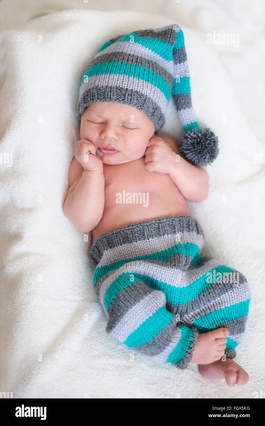 neugeborenes Baby schläft in einem Strick Anzug Stockfoto