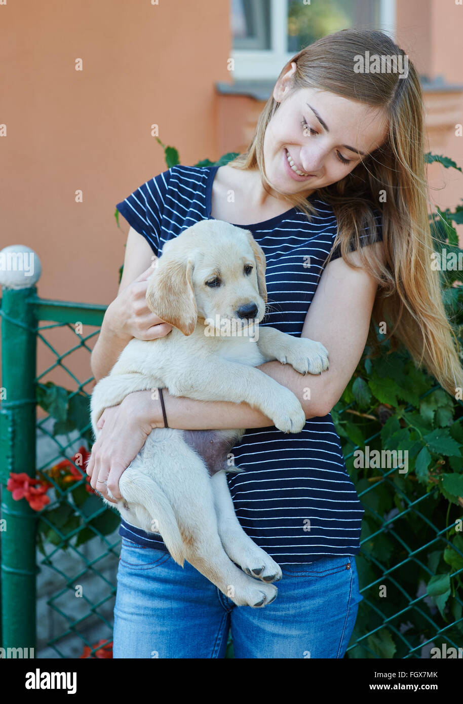 schöne blonde Frau spielt mit einem Welpen Labrador Stockfoto