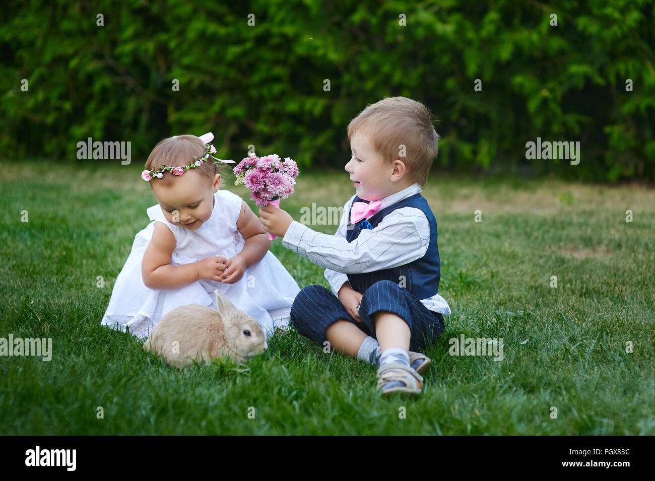 Kleiner Junge gibt einer Mädchen einen Blumenstrauß Stockfoto