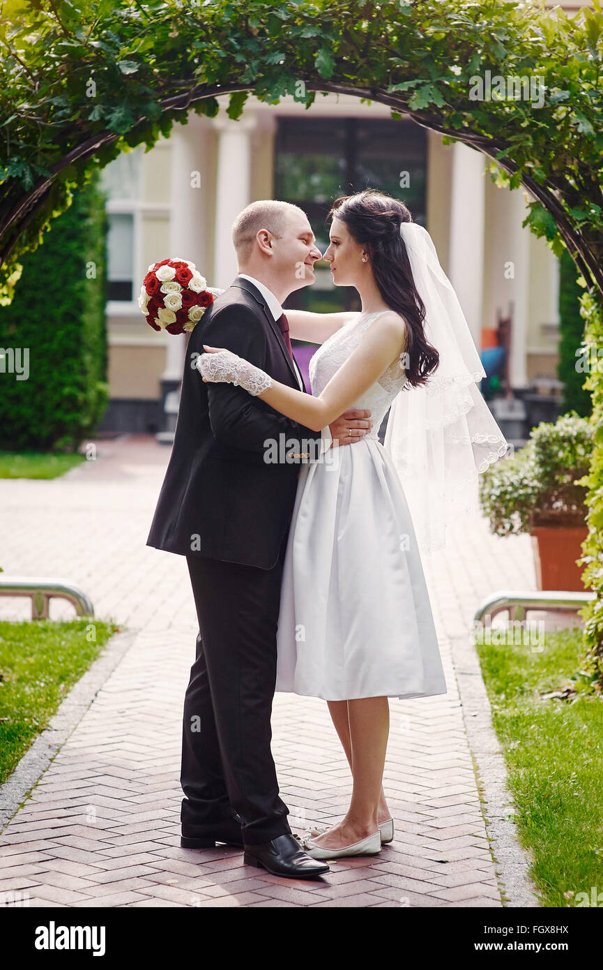 Bräutigam küssen seine Braut am Tag der Hochzeit in der Nähe von Bogen Stockfoto