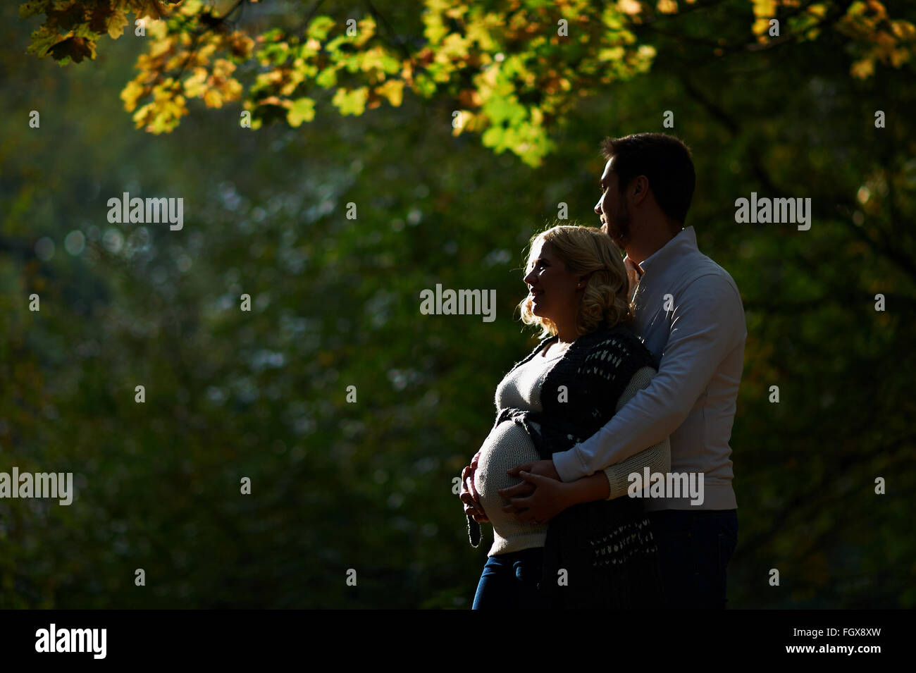 Mann und schwangere Frau sind im Park spazieren. Stockfoto