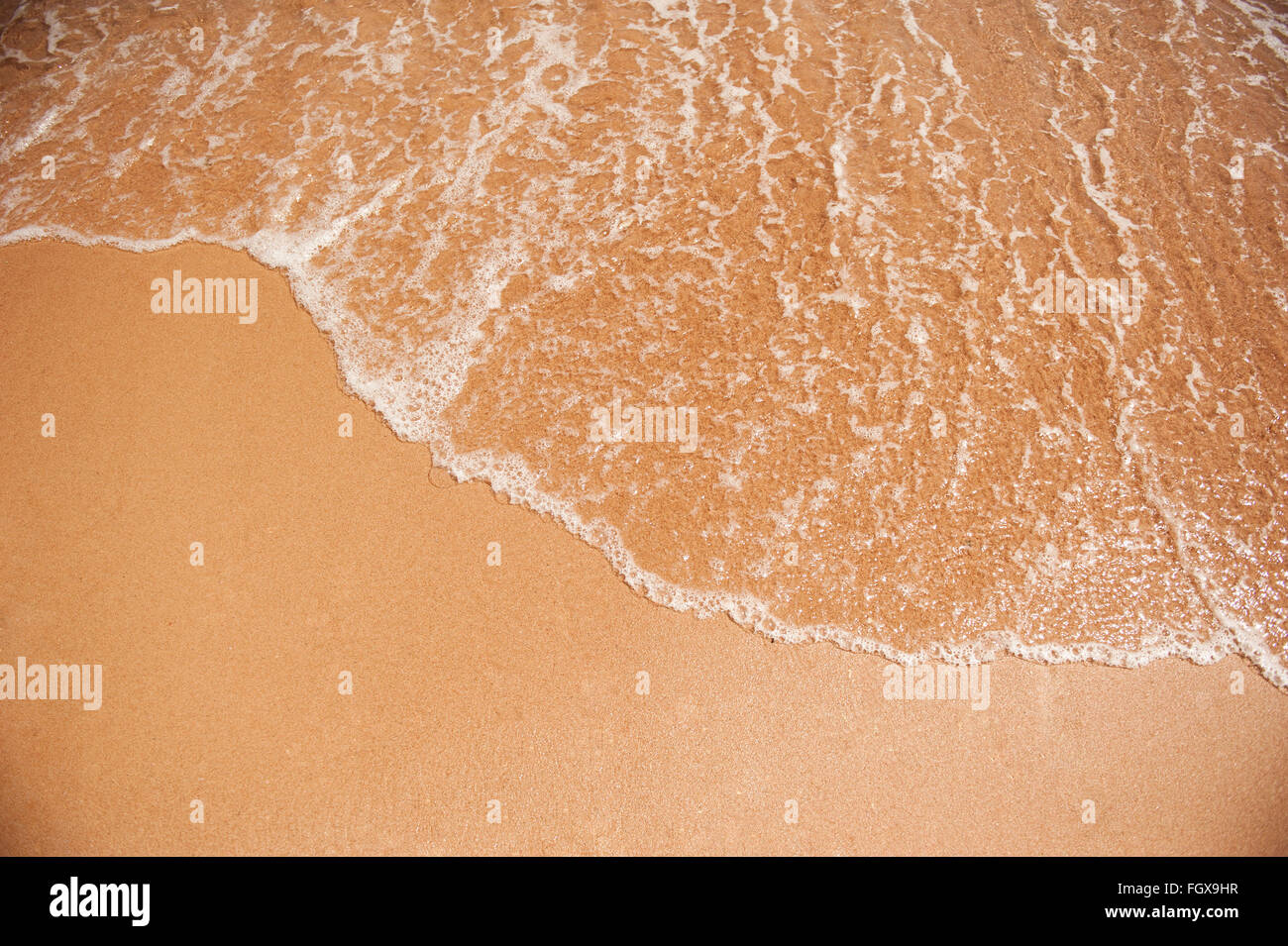 Flutwelle auf den gelben Sand am Strand Stockfoto