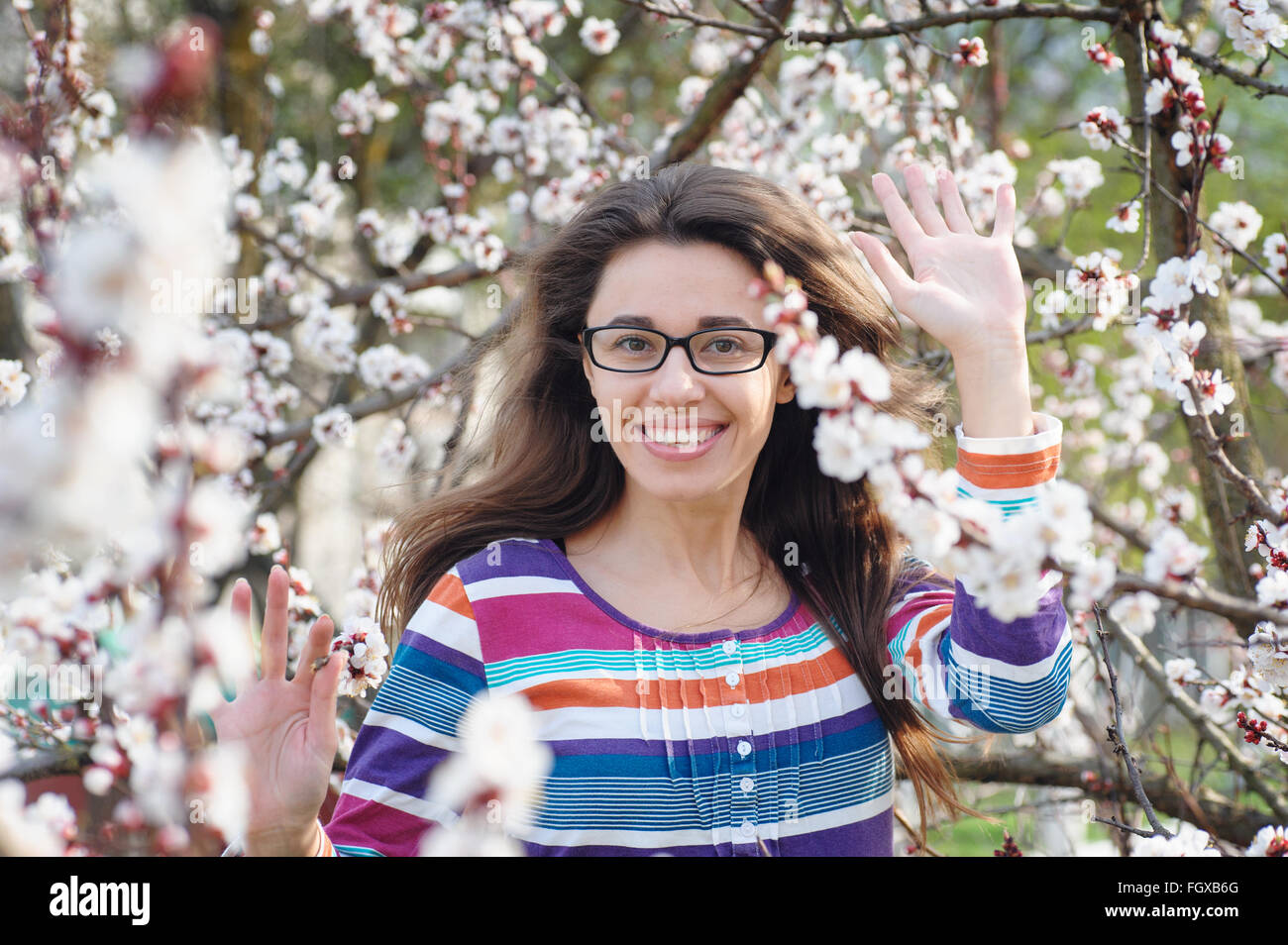 Schöne glückliche junge Frau Geruch in einem blühenden Frühlingsgarten genießen Stockfoto