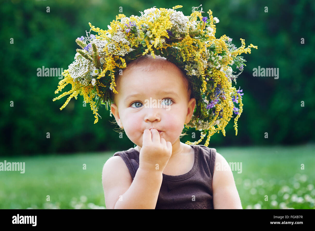 Schöne glückliches kleines Mädchen in einem Kranz auf einer Wiese auf die Natur Stockfoto