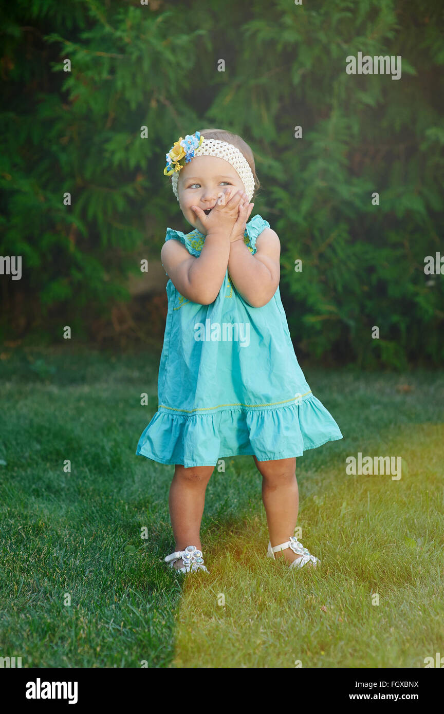 Kleine Mädchen spielen auf dem Rasen im Sommerpark Stockfoto